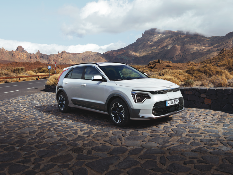 Kia Niro weiss auf Pflasterstrasse mit Berg im Hintergrund